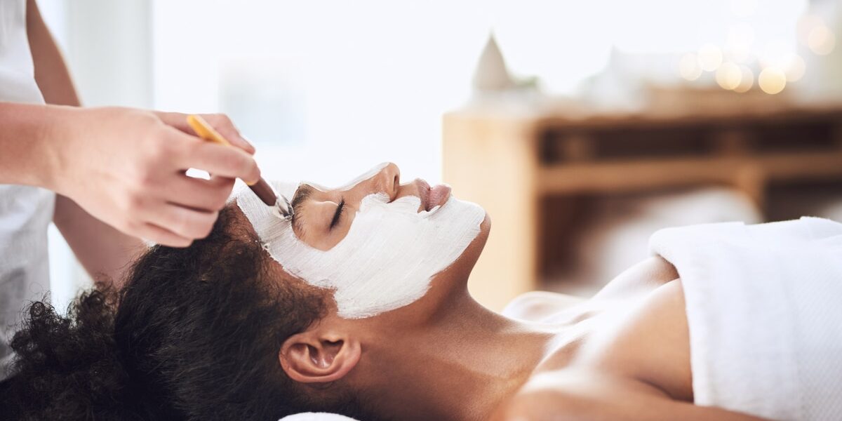 Shot of a young woman getting a facial treatment at a spa