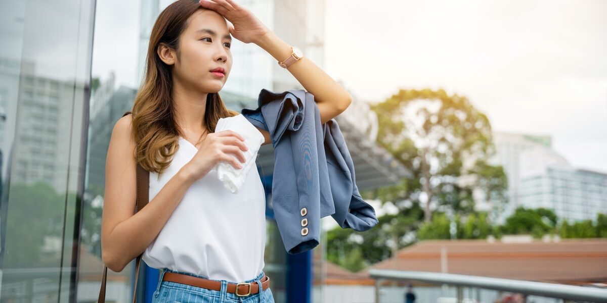 Asian beautiful business woman drying sweat her face with cloth in warm summer day hot weather Asian beautiful business woman drying sweat her face